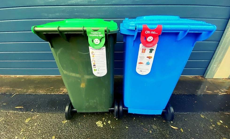 Blue and green bins with labels explaining what goes in them.