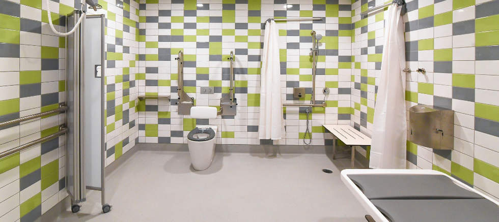 Interior of Changing Places green white and grey tiled spacious bathroom