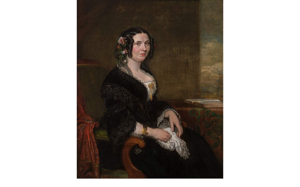 Painting of woman seated in a green armchair. She wears a black dress.