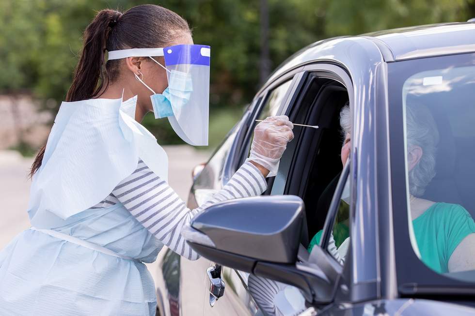 Nurse conducting a COVID-19 test at a drive through clinic