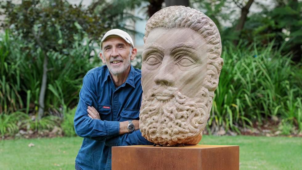Adrian Spurr stands next to his sculpture of a head located at Billilla gardens. 