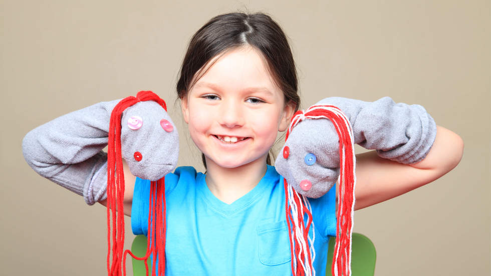 Little girl with sock puppets on her hands