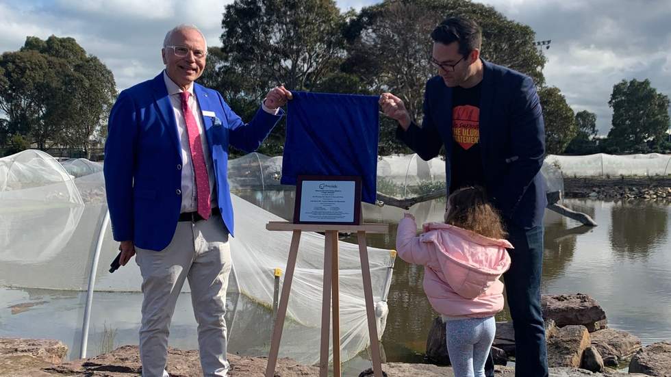 Two men and a little girl unveiling a plaque at Chain of Ponds