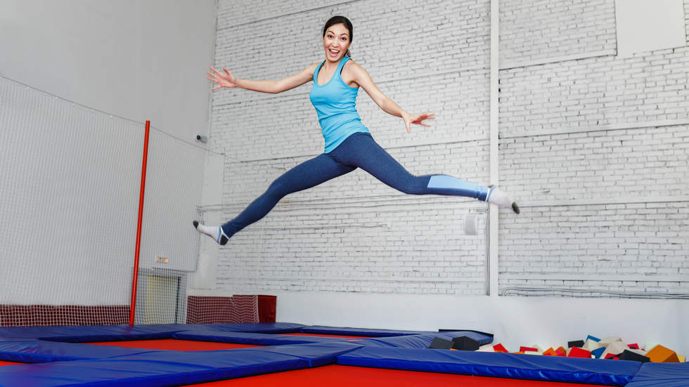 Young woman smiling and jumping in an indoor trampoline centre