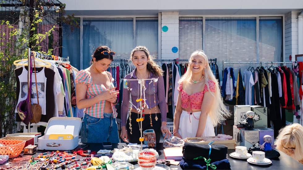 young women holding garage sale trail