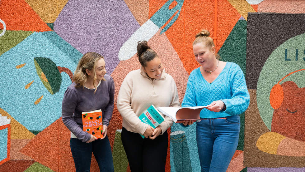 What's On at Bayside Library Service March booklet cover featuring 3 women standing in front of a colourful mural looking at books.