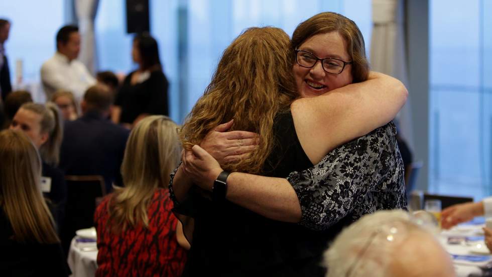 Two women hugging at event