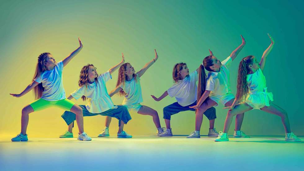 6 young women dancing under green lighting in a studio School Holiday Activities