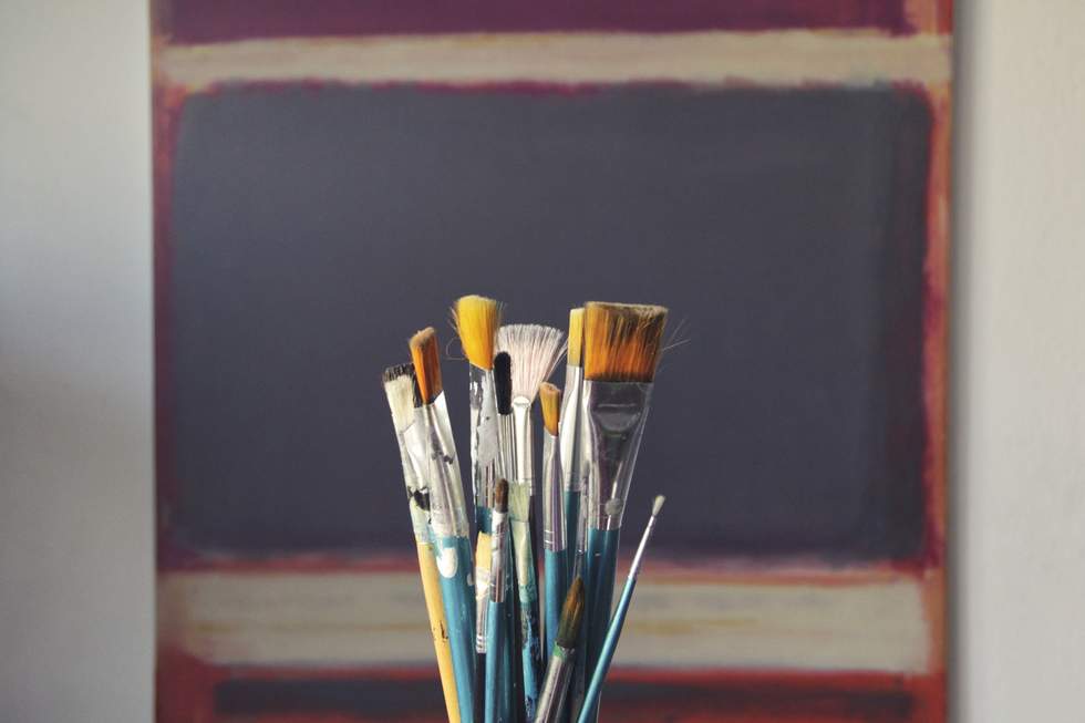 Several size paint brushes in a jar. 