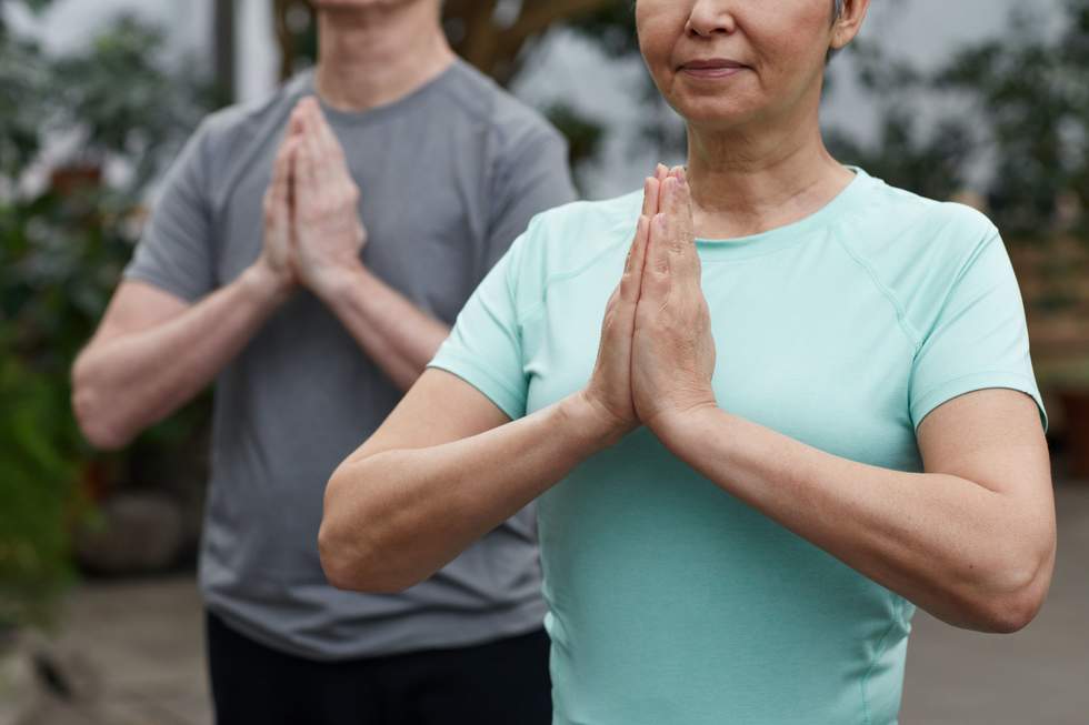 Image of a woman and a man in yoga pose. 