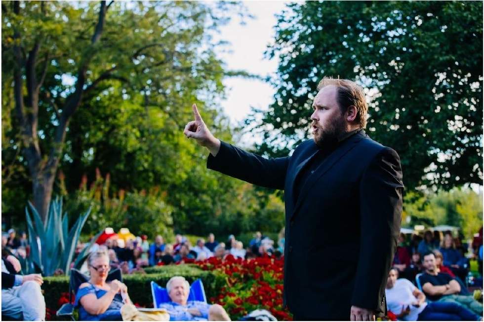 An opera singer singing in the park 