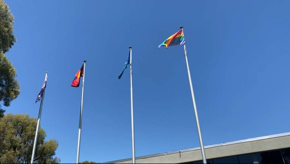 The Australian, Aboriginal, Torres Strait and Rainbow flags at full mast on poles