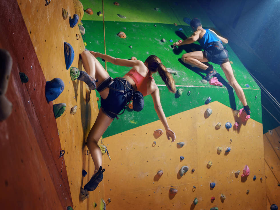 Two people rock climbing on a green and yellow wall School Holiday Activities