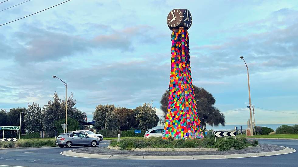 Black Rock Clock Tower with hundreds of colourful knitted squares covering the tower.