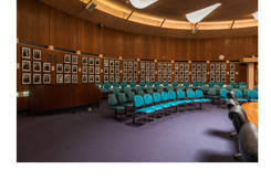 Interior of Council Chambers with aqua chairs and portraits on the wall