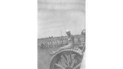 old black and white photo of girl on wheel by the sea
