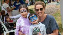 Woman and two kids with face paint on.