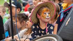 Child with face painted like a tiger.