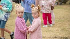 Two little girls holding hands at Easter event.