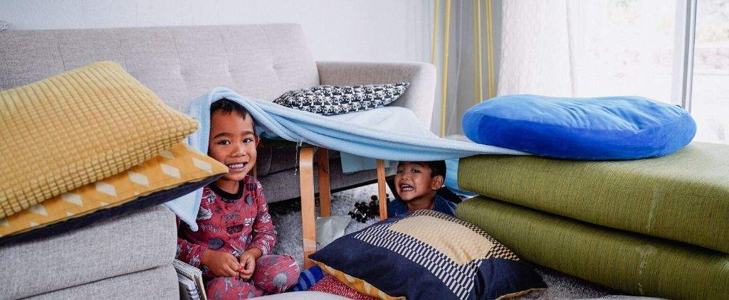 Two children building a fort. 