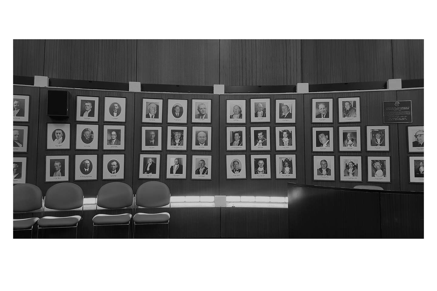 Interior of Council Chambers including a four chairs and portraits of former mayors installed