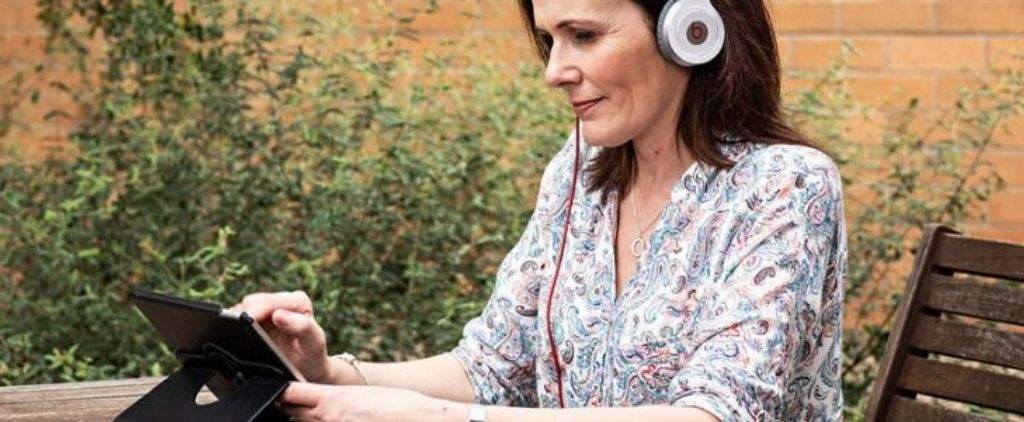 Woman listening to podcast on ipad.