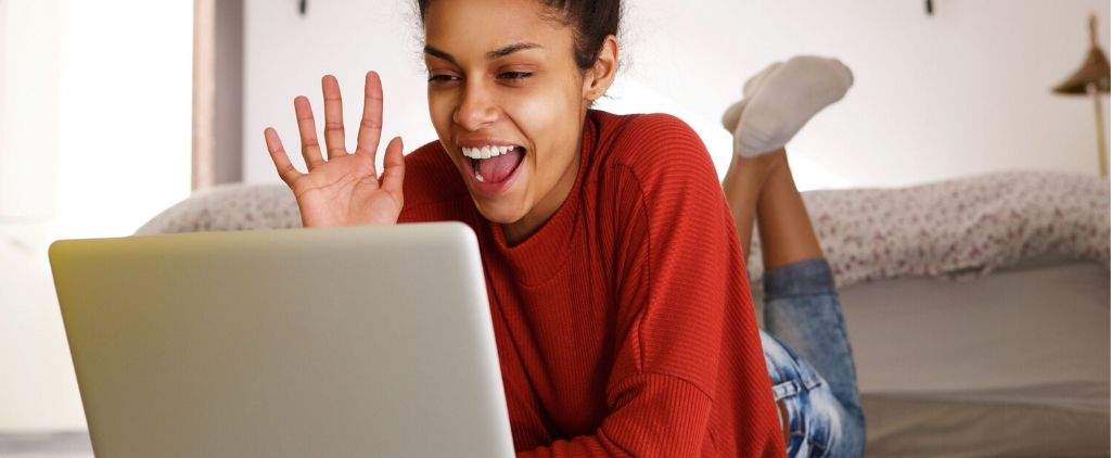 Happy woman waving at computer. 