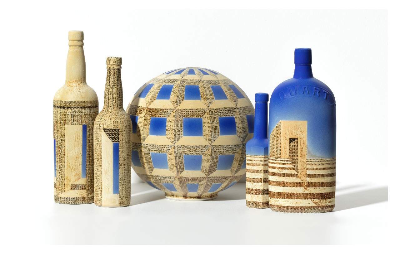 Five ceramic vessels painted in blue and cream, with geometric patterns.