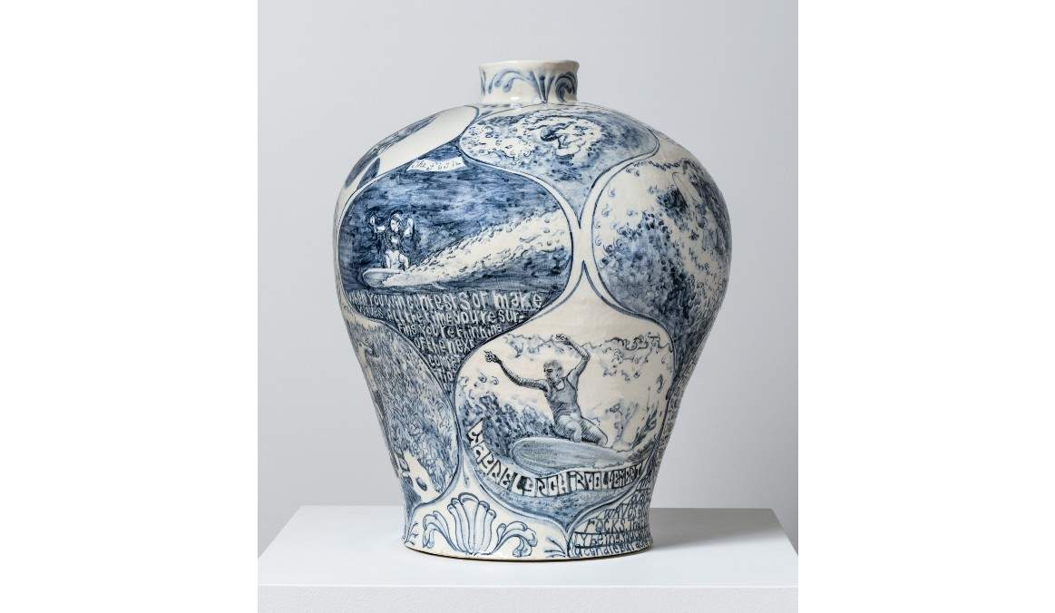 A large white ceramic vase, decorated with blue illustrations of surfers.