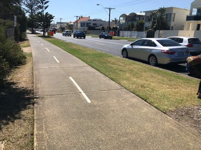 Bike path adjacent to Beach Road with cars parked and driving