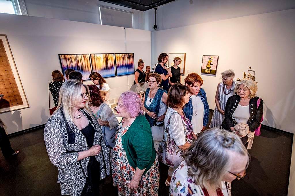 Overlooking a crowded room at a gallery exhibition.