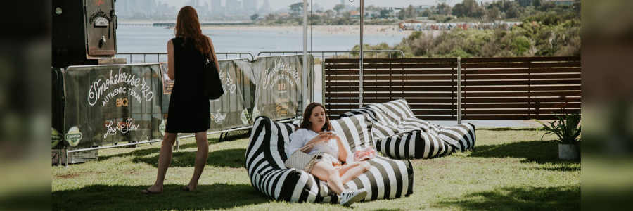Woman on a bean bag at Green Point eating 