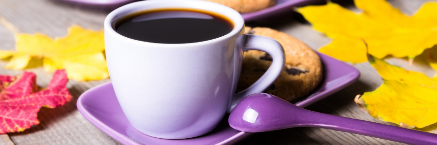 Cup of coffee with purple saucer and spoon