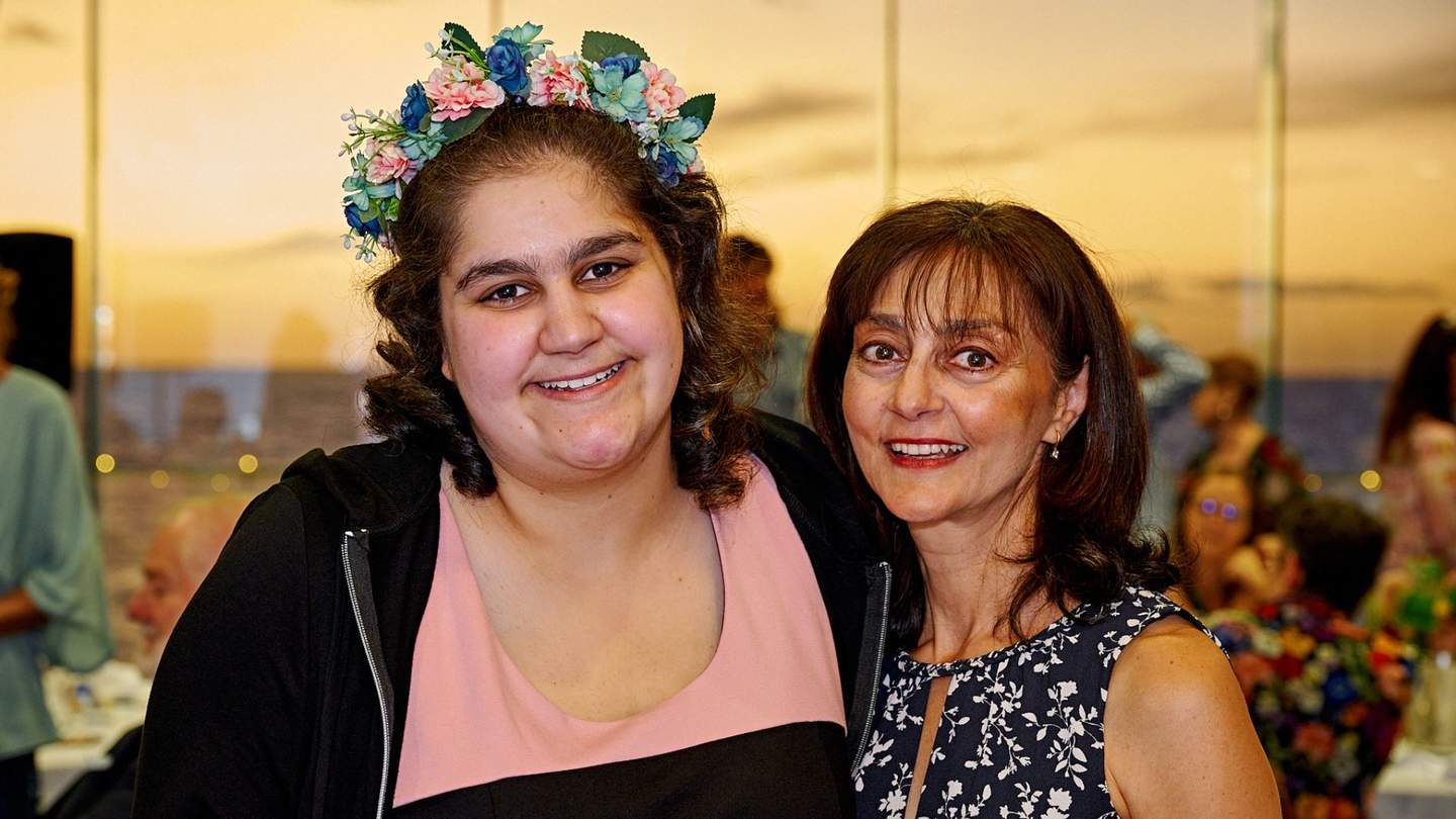 Happy girl with flowers in her hair with her mum at Aus Day Awards
