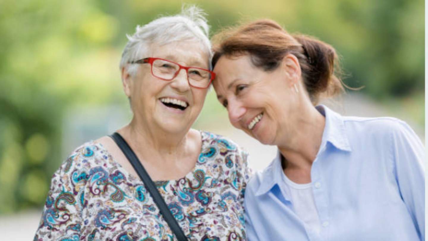 Two women laughing together on a walk