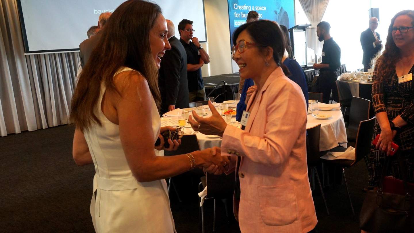 Two women greeting each other at event