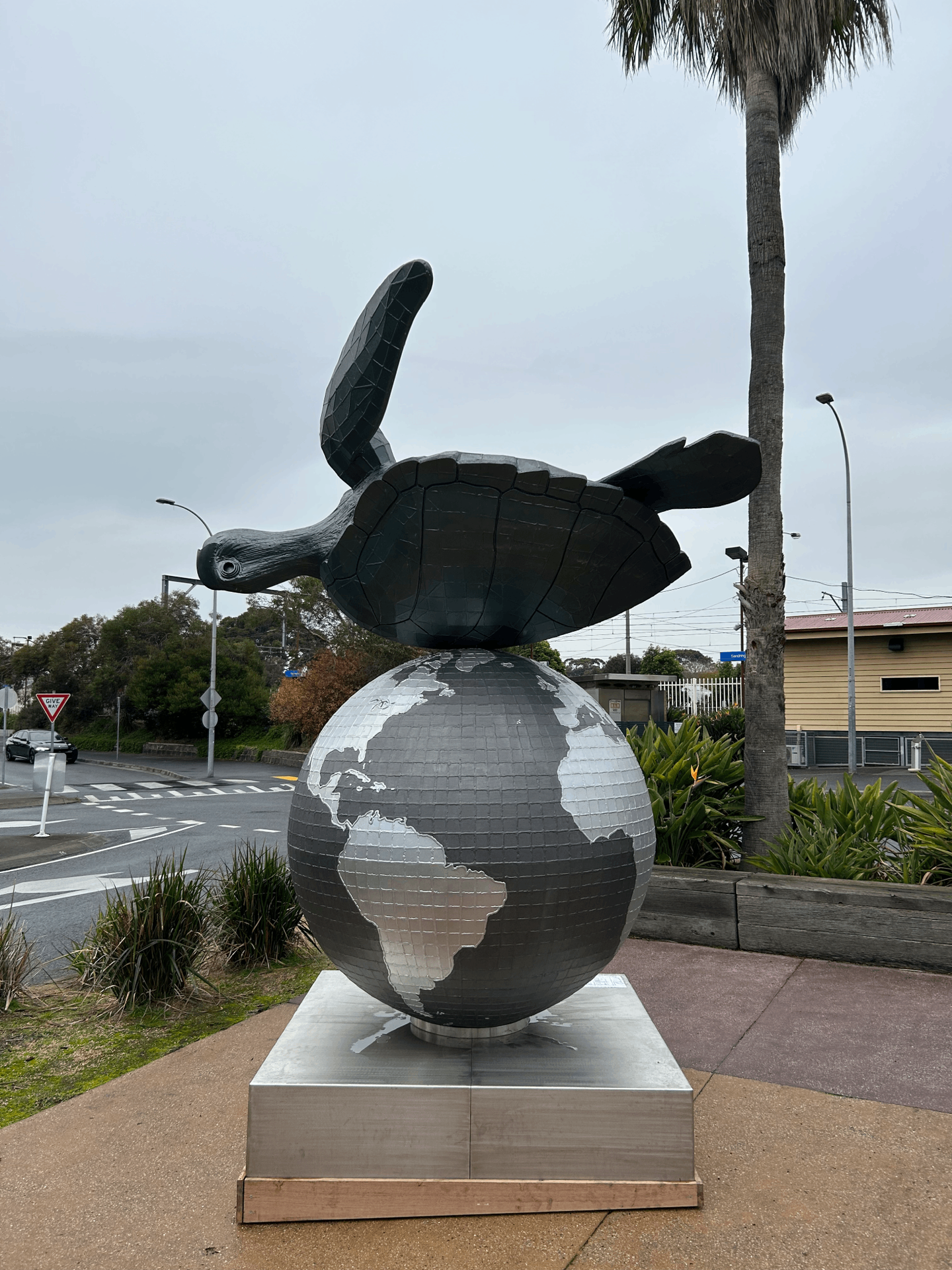 Sculpture of turtle on its back on top of globe