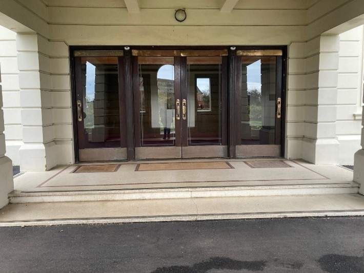Front entry to Brighton town hall, large brown glass doors. 