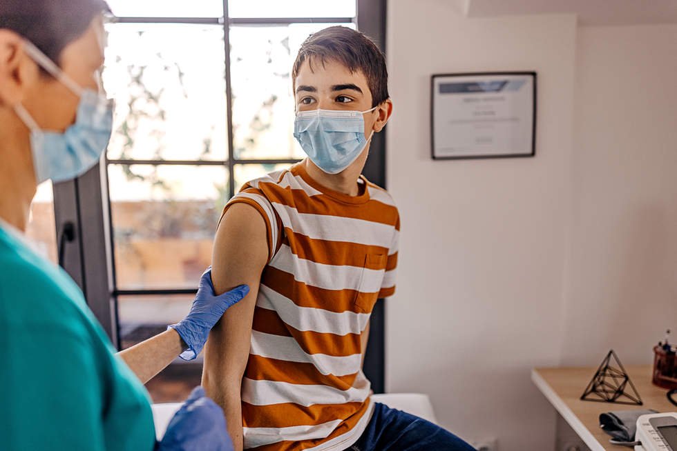 Young teenage boy with immunisation nurse