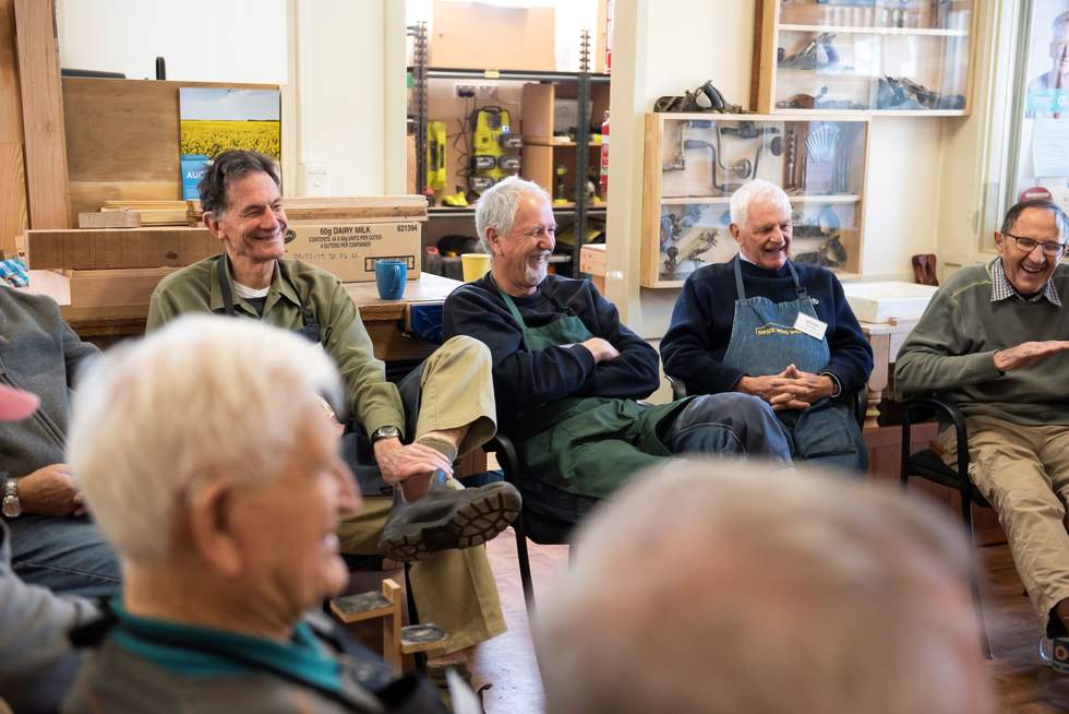 A group of men's shed participants laughing together