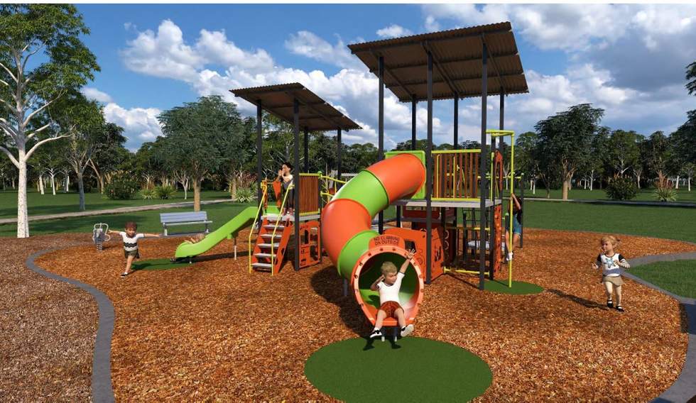 Playground equipment including two slides, climbing structure, children, tan bark, grass, trees
