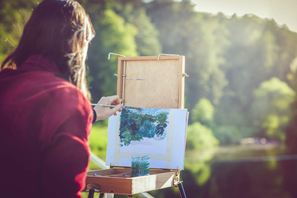 Person painting on a easel in nature