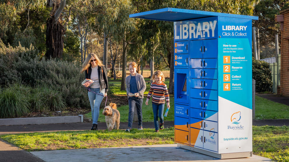 Mother and two children walking their dog to drop off their books at the Hurlingham  Library Locker