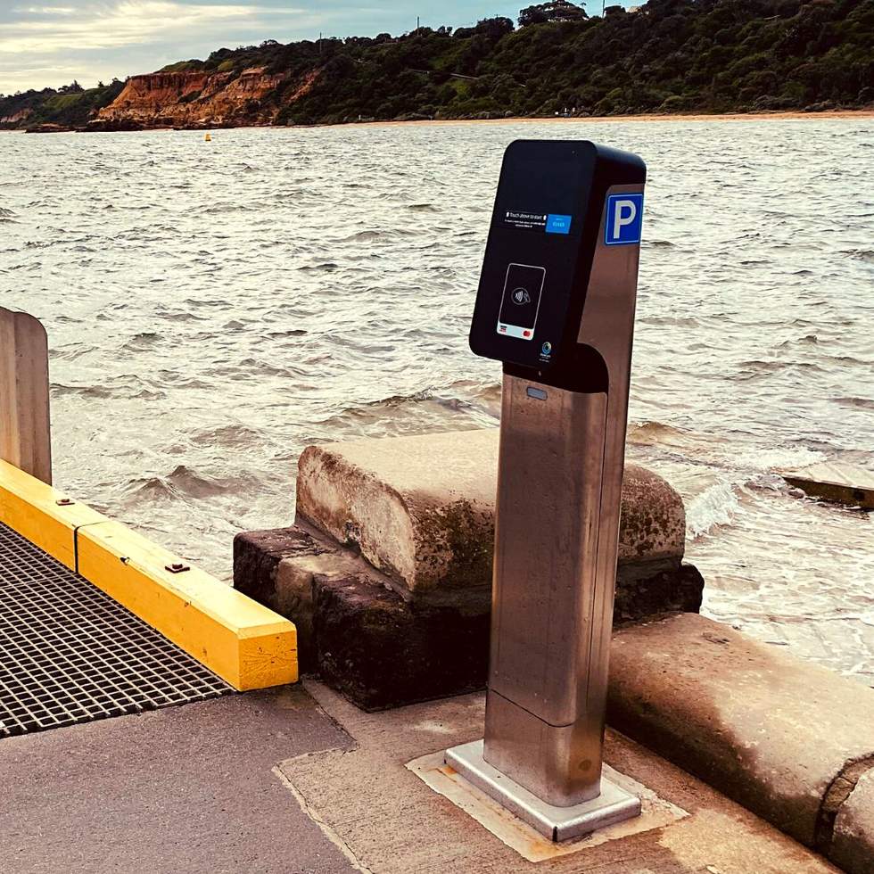 A slick looking parking meter by the sea