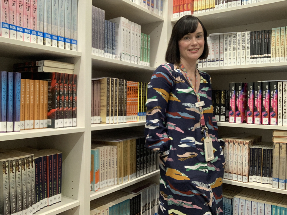 Librarian Kate standing in front of books on shelves