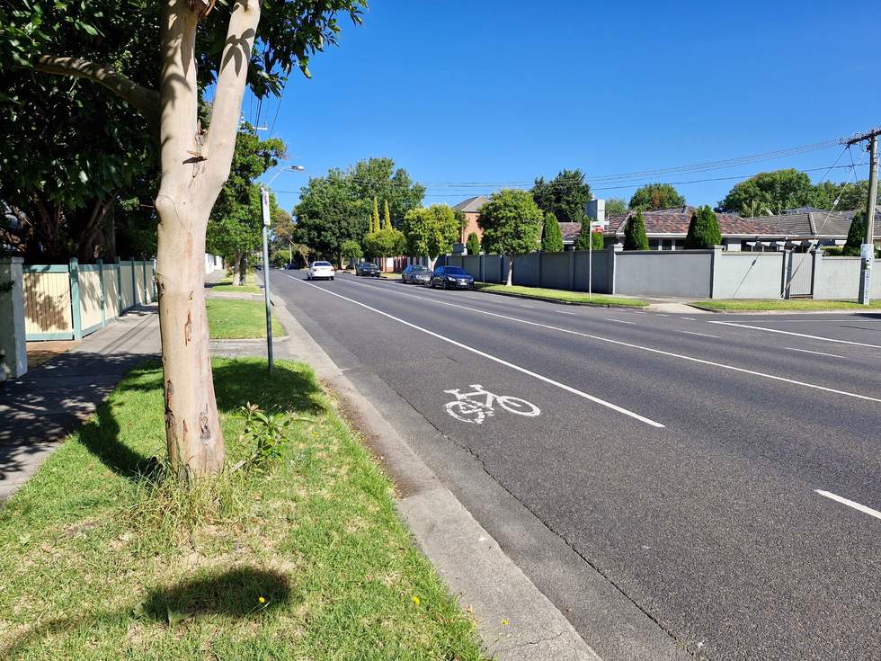 Balcombe Road on a blue sky sunny day showing the white painted bike lane lines with a white painted stencilled image of a bike